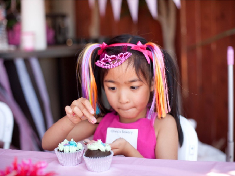 Girl kid decorating cupcakes
